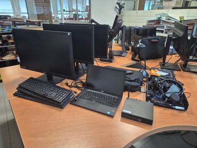 a desk with two monitors, a keyboard, a mouse, and a laptop on it