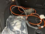 a car trunk with a bunch of cables and a cell phone in it