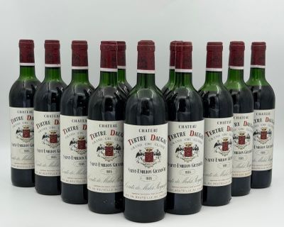 six bottles of wine are lined up in a row on a white surface