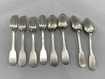 six spoons and six forks are lined up on a table