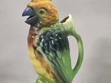 a ceramic bird that is sitting on top of a cup