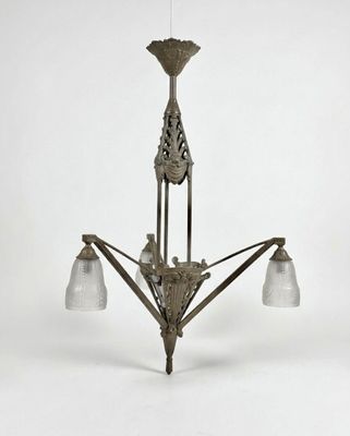 un lustre ancien muni de trois abat-jours en verre suspendu au plafond