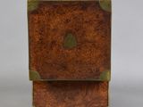 an antique wooden box with brass trims and a wooden base