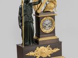 a statue of a man holding a clock on top of a table