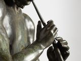bronze statue of a man with a trumpet in his hand