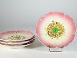 trois assiettes ornées de fleurs roses sur un fond blanc