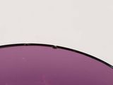 purple lens of a pair of sunglasses on a white surface