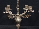 pair of antique brass candelabs on a black background