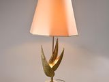 gold leaf table lamp with a white shade on a marble base