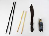 an image of a knife, chopsticks, and a figurine on a white surface