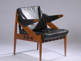 un fauteuil en cuir noir avec une structure en bois et une assise en cuir noir