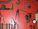 a red wall with a bunch of tools on it