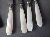 four pieces of silverware with mother of pearl on them