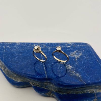 two silver rings sitting on top of a blue stone