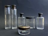 plusieurs bouteilles en verre vides avec leurs bouchons, posées sur une surface noire