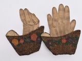 pair of leather gloves with floral designs on them on a white surface