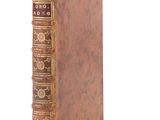 an old book sitting on top of a white surface