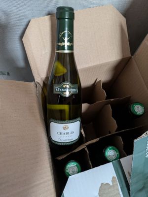 a bottle of wine in a cardboard box next to a bottle of wine