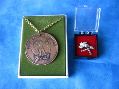 une petite boîte contenant un collier et une pièce de monnaie