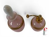 pair of pink glass perfume bottles with gold trim on a white background