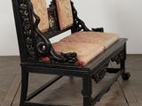 a black bench with a cushion on it on a wooden floor