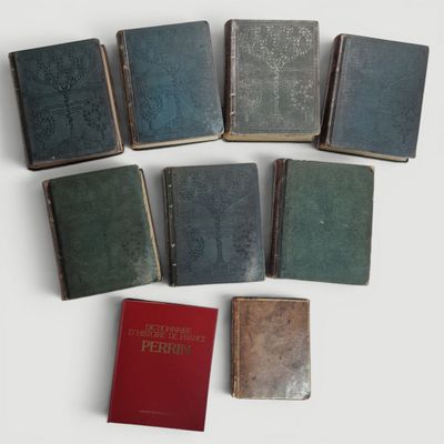 plusieurs vieux livres posés sur une table blanche, à côté d'un livre rouge
