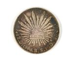 an old coin with a sunburst on it on a white surface
