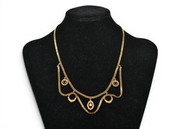 a black mannequin with a gold necklace on it
