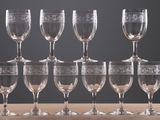 several empty wine glasses are lined up on a wooden table