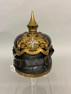 an old black and gold helmet with a gold crown on it