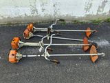 several lawn mowers are lined up on the ground in a parking lot