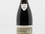 une bouteille de vin rouge posée sur une table blanche
