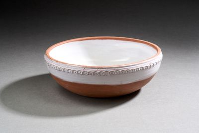 un bol marron et blanc posé sur une table