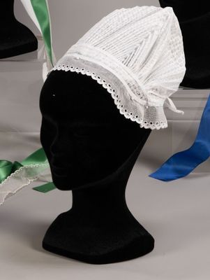 a white hat with a green ribbon on top of it