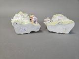 two figurines of people sitting on a rock