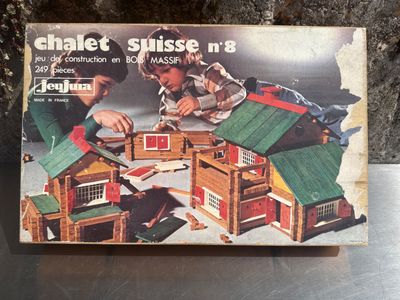 une boîte sur laquelle figurent deux enfants jouant avec une maison de poupées