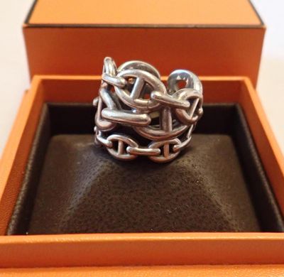 une image représentant une bague en argent dans une boîte, entourée d'une chaîne