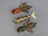trois broches en forme de poisson posées sur une table