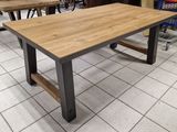 La table est en bois et en métal, avec un plateau en bois.