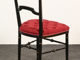 a black chair with a red cushion on it