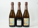 trois bouteilles de vin posées les unes à côté des autres sur une surface blanche
