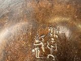 a close up of a bronze vase with writing on it