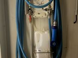 un tuyau bleu fixé au mur, sur lequel est accrochée une horloge