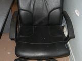 une chaise de bureau noire avec une pancarte fixée à l'arrière