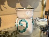 une vitrine en verre remplie de vases et d'autres objets décoratifs