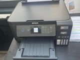une imprimante noire posée sur un bureau près d'une fenêtre