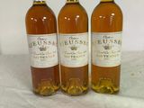 three bottles of wine sitting on top of a table next to each other