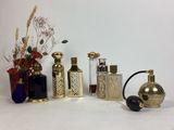 de nombreux flacons de parfum et vases de toutes sortes sur la table