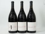 three bottles of wine are lined up on a white surface