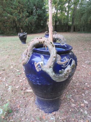 un vase bleu orné d'un dragon, posé dans l'herbe